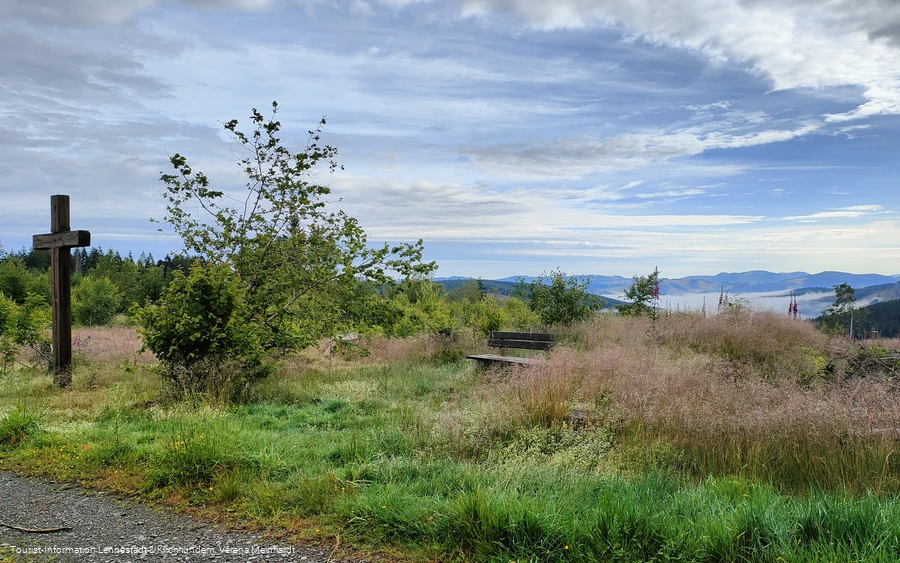 Kreuz mit Bank am Wegesrand